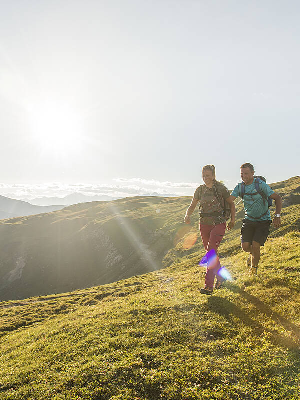 Paar wandert mit Bergpanorma der Nockberge im UNESCO Biosphärenpark 