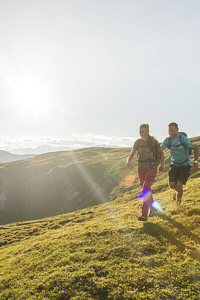 Paar wandert mit Bergpanorma der Nockberge im UNESCO Biosphärenpark 