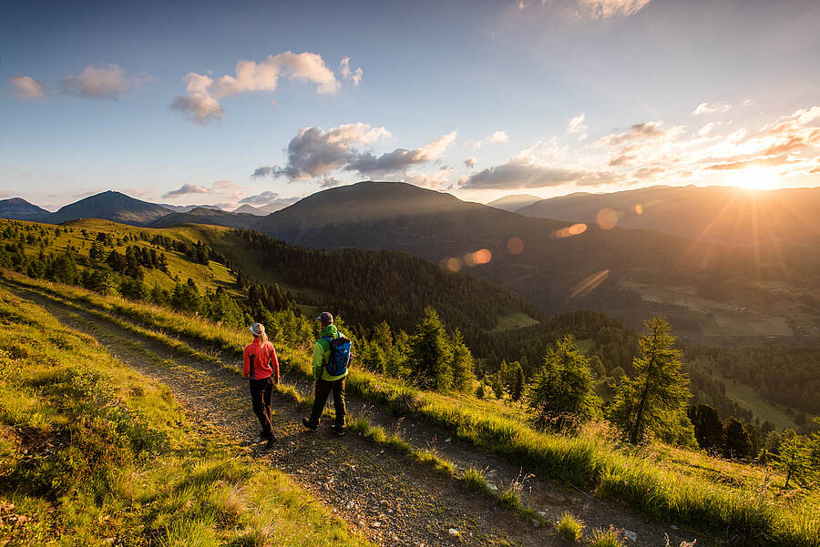 Wanderer auf Etappe 4 des Nockberge Trail mit Panorama über die Nockberge Richtung Falkertsee im UNESCO Biosphärenpark.
