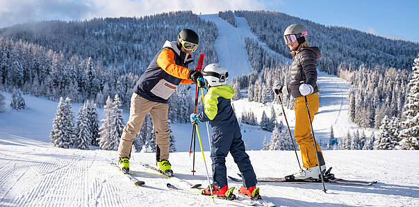 Familie genießt einen Wintertag auf den Skipisten der Hochrindl in Kärnten