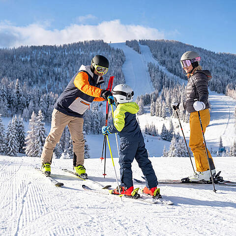 Familie genießt einen Wintertag auf den Skipisten der Hochrindl in Kärnten