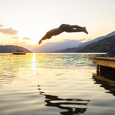 Ein erfrischender Sprung ins Wasser des Millstätter Sees bei Sonnenuntergang © Gert Perauer_MBN Tourismus