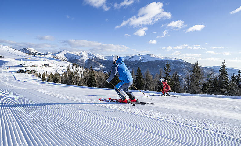 2 Skifahrer fahren nebeneinander die Piste im Skigebiet Bad Kleinkirchheim hinunter