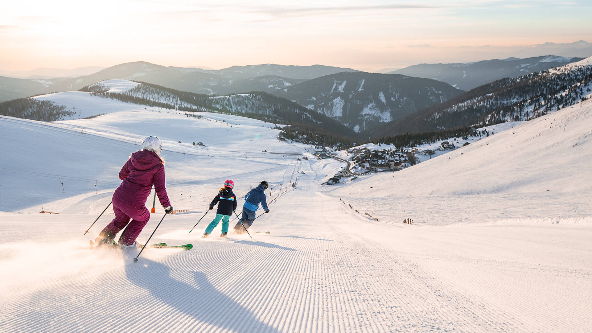 Familie fährt zusammen eine Piste am Falkert hinunter