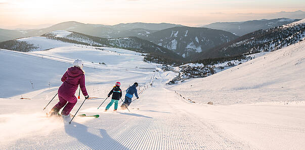 Familie fährt zusammen eine Piste am Falkert hinunter