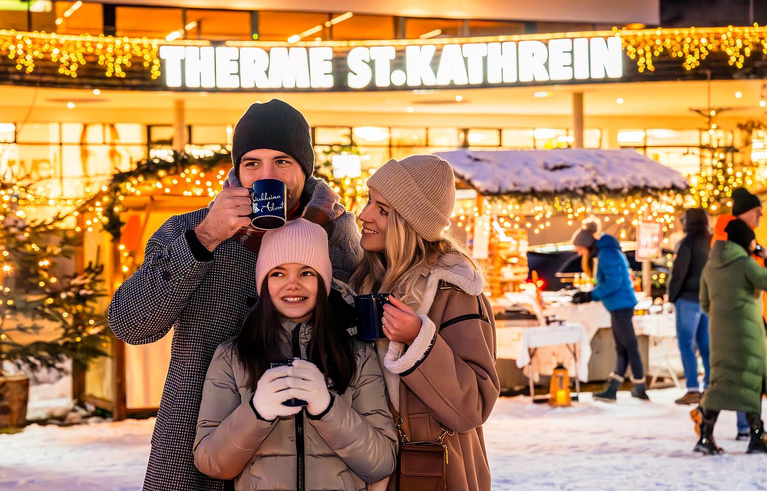 Glückliche Familie am Kirchheimer Adventmarkt Glückliche Familie steht am Kirchheimer Adventmarkt und trinkt ein ein heißes Getränk