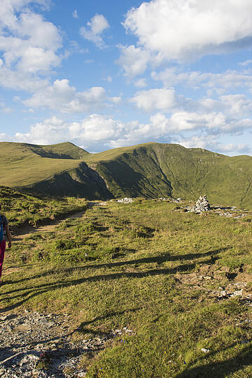 Kletterer erklimmen eine steile Felswand mit dem weiten Tal im Hintergrund © Franz Gerdl