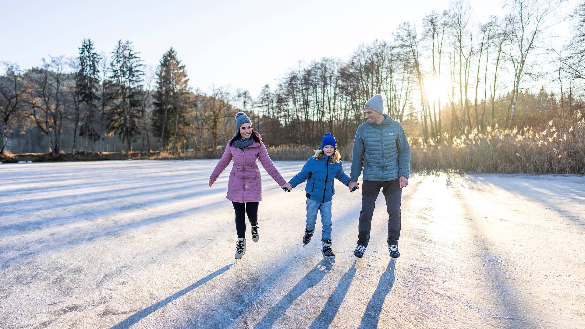 Eltern und Kind beim Eislaufen am Flatschacher See
