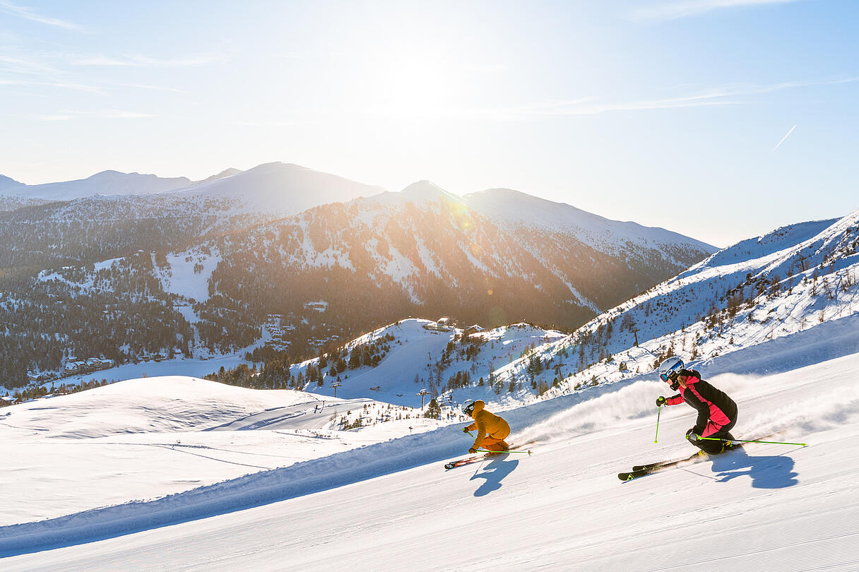 Skifahrer fahren die Piste auf der Turracher Höhe hinunter